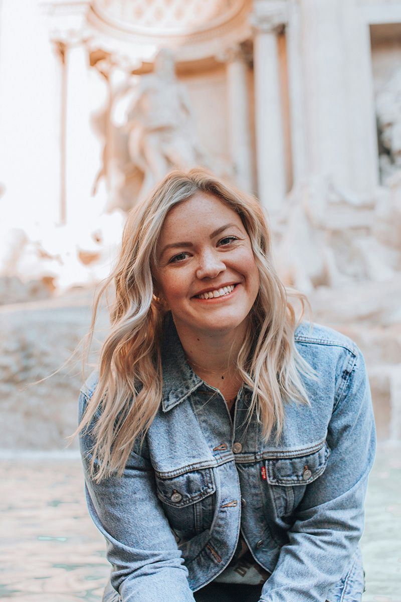 Eine lächelnde junge Frau mit blonden Haaren und einer Jeansjacke