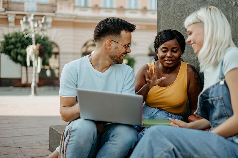 Eine Gruppe von College-Studenten, die draußen reden und studieren