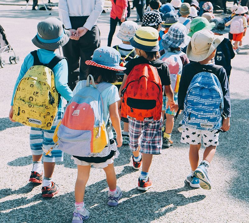 Bunt angezogene Kinder auf dem Weg zur Schule
